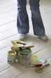 Woman standing by painting materials on floor