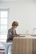 Boy using laptop at kitchen table
