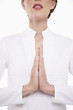 Woman with hands together praying, head and shoulders