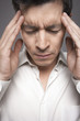Man with fingers pressed to forehead, close-up