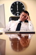  Businessman sitting at his desk lost in thought