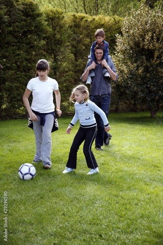 Photo: Man and children playing soccer Man and children playing soccer