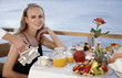 Young woman having breakfast on hotel terrace