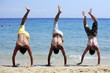 Three young men doing handstands on beach