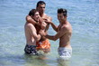 Three young men playing in the water