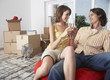 Couple with champagne in house with red chair celebrating