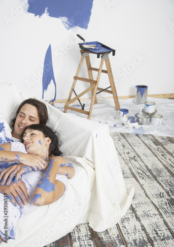Photo: Man and woman on sofa with paint Man and woman on sofa with paint