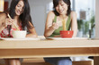 Young Women eating bowl of noodles with chopsticks in cafeteria