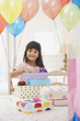 Girl with birthday presents and balloons