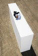 Businessman on wall outdoors in foetal position