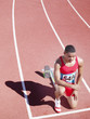 Racer at start line on track kneeling