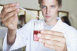 Man in a laboratory measuring liquids with an eyedropper