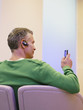 man sitting with headset and mobile phone
