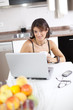 Modern woman reading e-mails at her breakfast