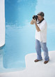 Man outdoors by swimming pool using camera