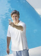 Man outdoors by swimming pool with his mobile phone