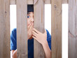 child looking through a fence