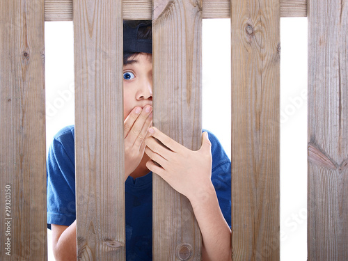 Photo: child looking through a fence child looking through a fence