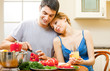 Young happy smiling couple cooking together at home