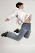 young teenage boy jumping in jeans and white shirt