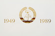 Staatswappen der DDR (goldene Lettern im Hochdruck auf Papier)