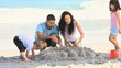 Parents building a sand castle with their children