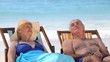 Aged couple relaxing on beach chairs