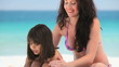 Mother putting sunscreen on her daughter