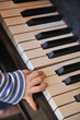 Kinderhand auf Klaviertasten