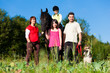 Familie mit Kindern steht vor einem Pferd