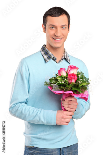 Photo: Young smiling man holding a bouquet of flowers Young smiling man holding a bouquet of flowers