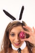 Ein Osterhase versteckt sein Auge mit einem Osterei