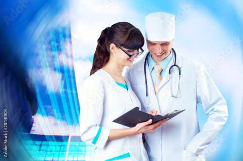 Photo: Smiling medical doctor with stethoscope on the hospitals backgro Smiling medical doctor with stethoscope on the hospitals backgro