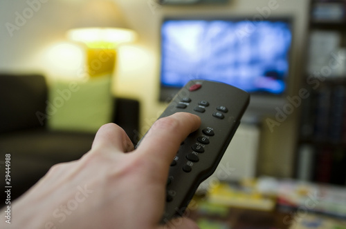 Photo: Zapping TV avec télécommande le soir à la maison Zapping TV avec télécommande le soir à la maison