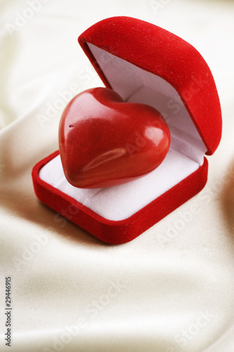 Photo: Valentine concept. Red velvet Gift Box with a heart Valentine concept. Red velvet Gift Box with a heart