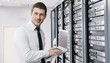 businessman with laptop in network server room