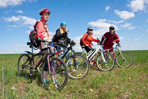 Photo: A group of four adults on bicycles in the countryside. A group of four adults on bicycles in the countryside.
