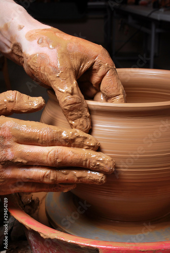 Photo : hands of a potter, creating an earthen jar on the circle hands of a potter, creating an earthen jar on the circle