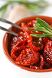 Sundried tomatoes and rosemary in a ceramic bowl.