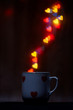Mug with steam of glowing hearts on dark background