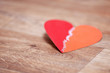 Heart sewn from two halves lies on the wooden floor