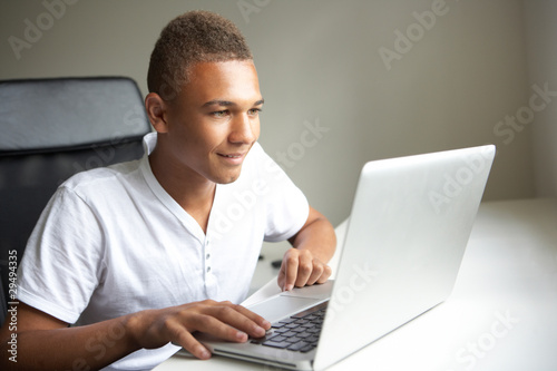 Photo: Teenage Boy Using Laptop At Home Teenage Boy Using Laptop At Home