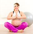 Photo: Smiling beautiful pregnant woman doing yoga exercises Smiling beautiful pregnant woman doing yoga exercises