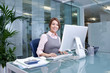 Foto: Smiling businesswoman working at computer in office Smiling businesswoman working at computer in office