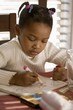 Little Girl Coloring A Picture At The Table