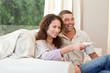 Couple watching tv in their living room at home Couple watching tv in their living room at home