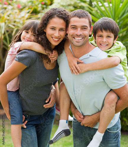 Foto: Mother and father giving children a piggyback Mother and father giving children a piggyback