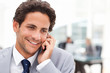 Charming businessman phoning in his office Charming businessman phoning in his office