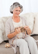 Senior woman knitting on her sofa Senior woman knitting on her sofa