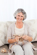 Senior woman knitting on her sofa Senior woman knitting on her sofa